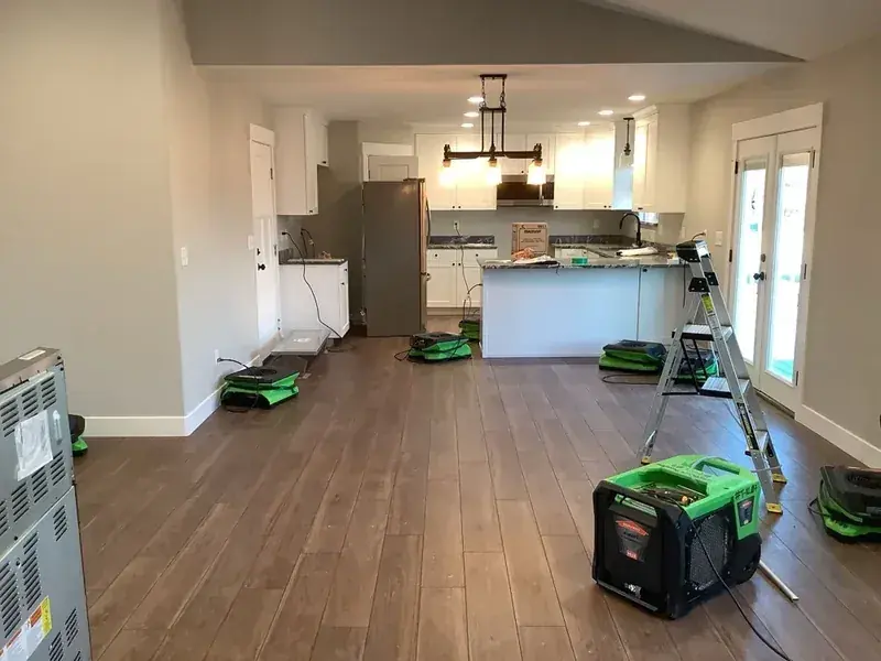Restoration technician extracting standing water from a flooded Alpine, UT home
